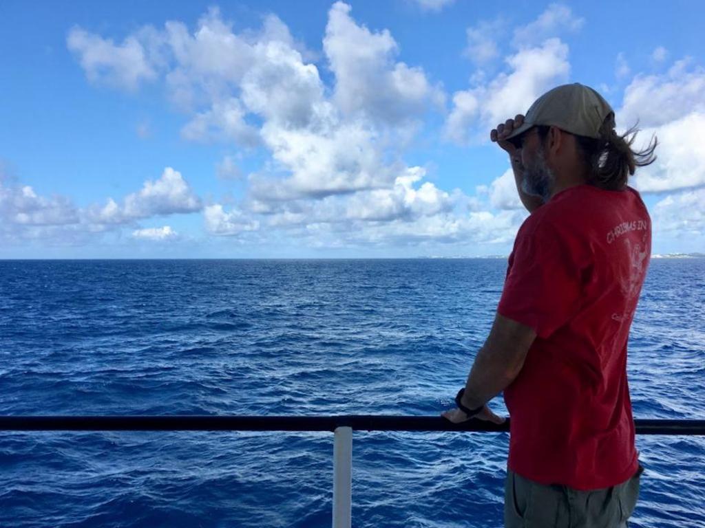 Michael Gonsior stands at the rail of the ship looking at the horizon