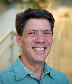 A professional headshot of Eric Schott in the IMET lobby