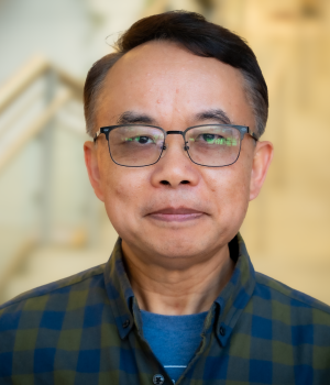 A professional headshot of Feng Chen in the IMET lobby