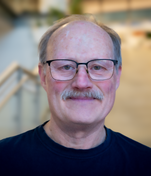 A professional headshot of Hal Schreier in the IMET lobby