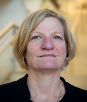 A professional headshot of Jenn Burns in the IMET lobby 
