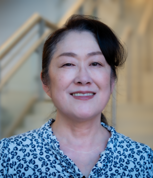 A professional headshot of Keiko Saito in the IMET lobby