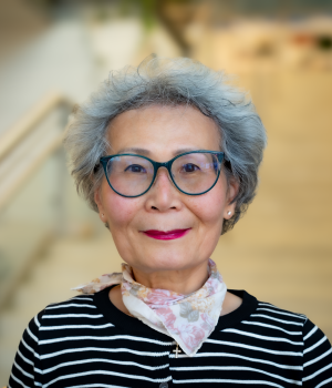A professional headshot of Sook Chung in the IMET lobby