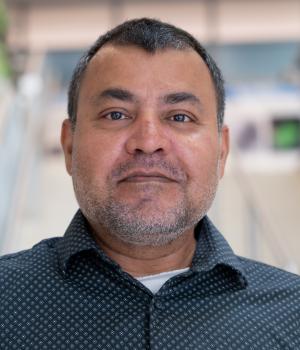 A professional headshot of Som Chatterjee in the IMET lobby