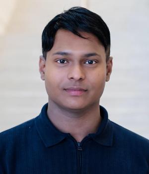 A professional headshot of Vijay in the IMET Lobby