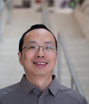 A professional headshot of Yantao Li in the IMET lobby
