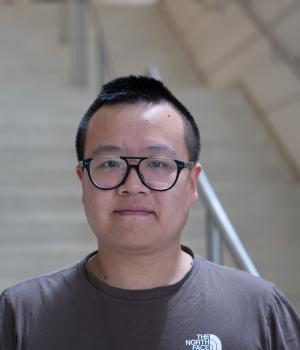 A professional headshot of Zhongshi He in the IMET lobby 