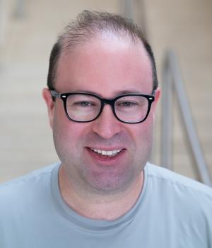 A professional headshot of Jonas in the IMET lobby