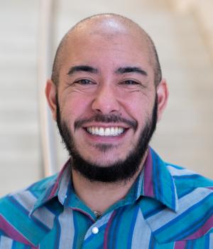 A professional headshot of Kieran in the IMET Lobby
