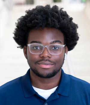 A professional headshot of Dumeje in the IMET Lobby