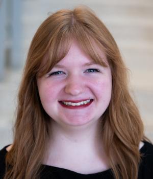 A professional headshot of Emily in the IMET lobby