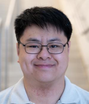 A professional headshot of Raymond in the IMET lobby