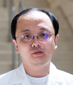 A professional headshot of Yang in the IMET lobby
