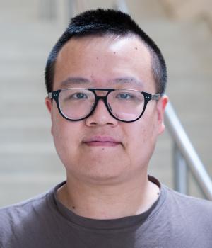 A professional headshot of Zhongshi He in the IMET lobby 