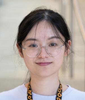 A professional headshot of Jing in the IMET lobby