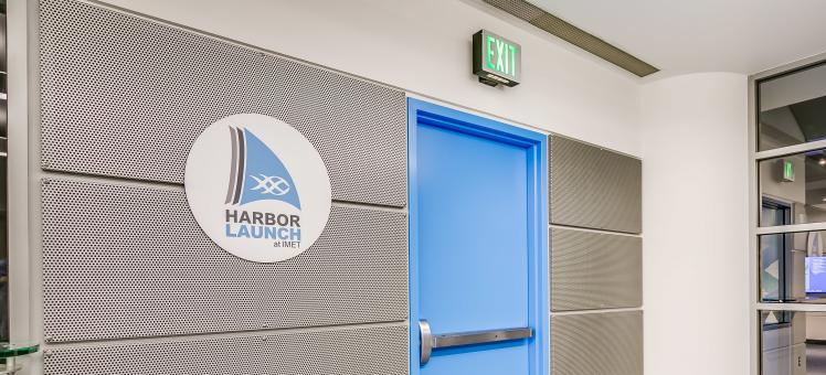 blue door with Harbor Launch Logo on wall