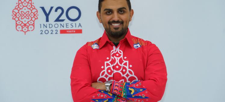 Majeed Alrefaie smiling in front of Y20 Indonesia logo