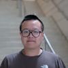 A professional headshot of Zhongshi He in the IMET lobby 