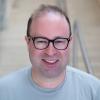 A professional headshot of Jonas in the IMET lobby