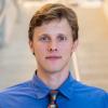 A professional headshot of Max in the IMET lobby