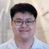 A professional headshot of Raymond in the IMET lobby