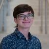 A professional headshot of Sam in the IMET lobby