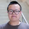 A professional headshot of Zhongshi He in the IMET lobby 