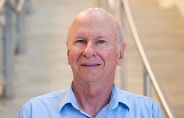 A professional headshot of Russell in the IMET lobby
