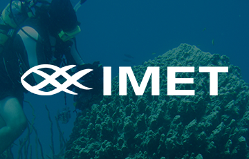 White text logo for "IMET" with an abstract fish icon, overlaid on a blue-toned underwater scene of a scuba diver near a coral reef.